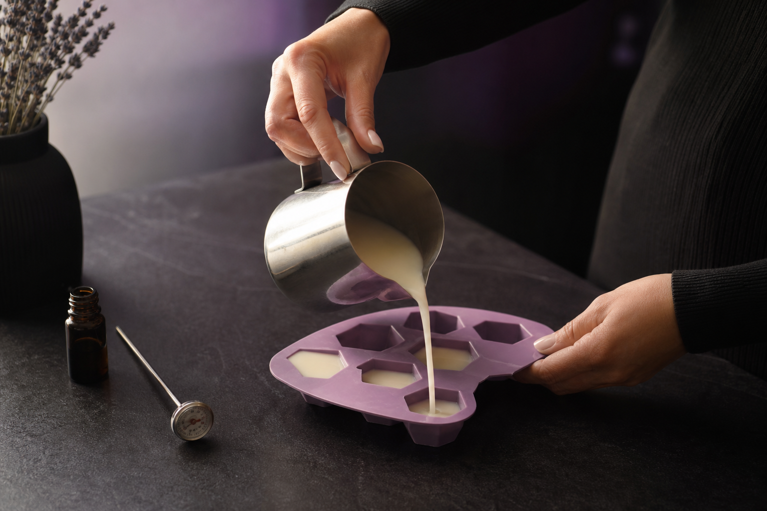 Hands carefully pouring wax into a silicone mould